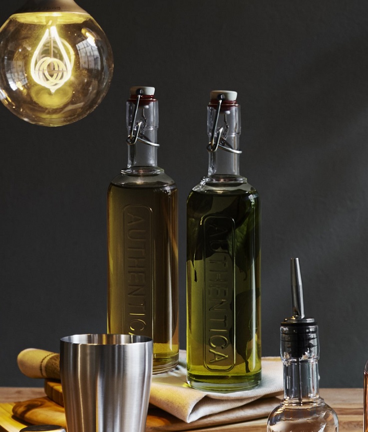 mit Olivenöl gefüllte Flaschen Optima Authentica, mit Edelstahlbügelverschluss, mit  sichtbarer Ausgusshilfe im Vordergrund
