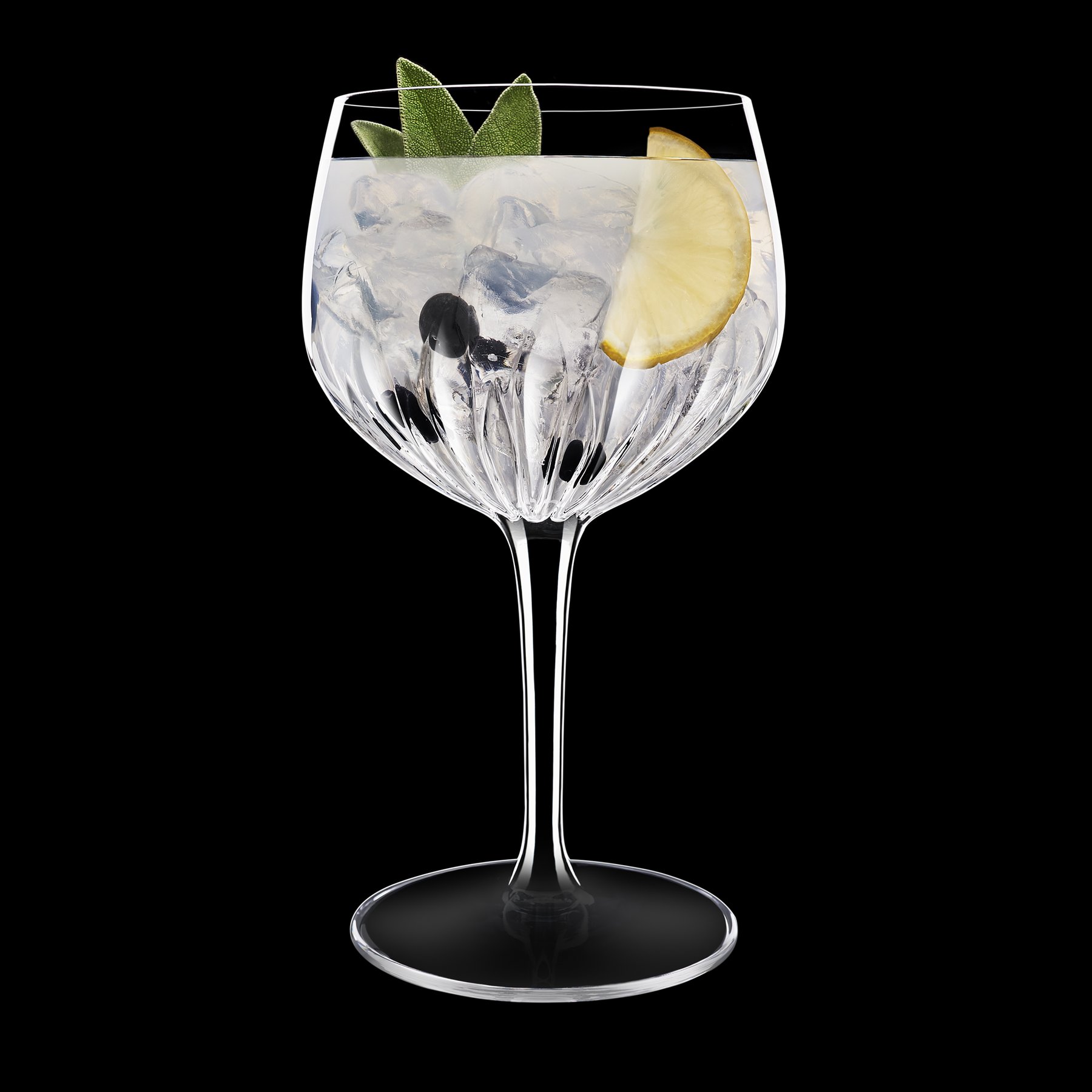 Mixology Spanish Gin & Tonic Glas 800 ml, gefüllt mit Gin, Eis, Wacholderbeere, Zitronenscheibe, dunkler HIntergrund